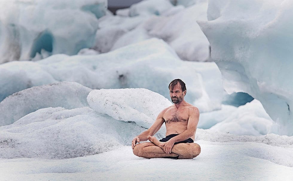 een man zittend in een meditatiepositie voor ijsformaties.